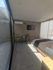 a bedroom with a bed and a table and chairs at Riviera Mendoza in Las Compuertas