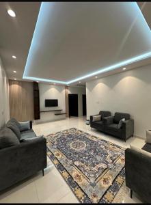 a living room with two couches and a rug at شقق اطلالة الضباب الباحه in Al Baha +3 photos