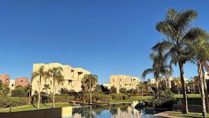 a view of a resort with palm trees and a canal at La Perle de Marrakech in Marrakesh