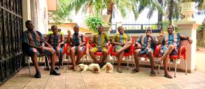 a group of people sitting in chairs with a dog at The Close in Asaba