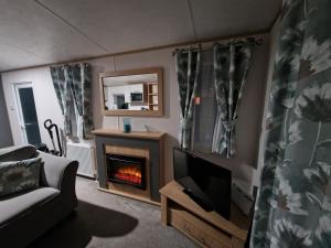 a living room with a fireplace and a couch at Georgina Meadows in Skipsea
