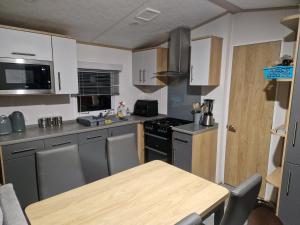 a small kitchen with a wooden table and a counter top at Georgina Meadows in Skipsea