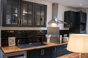 a kitchen with black cabinets and a sink at Chez Léon in Hasnon