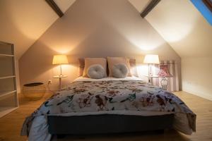 a bedroom with a large bed in a attic at Chez Léon in Hasnon +9 photos
