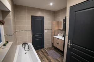 a bathroom with a black door and a sink at Chez Léon in Hasnon