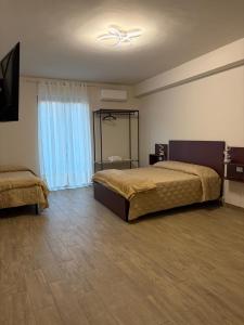 ein Schlafzimmer mit zwei Betten und einem Deckenventilator in der Unterkunft Capizzi Rooms in Bronte