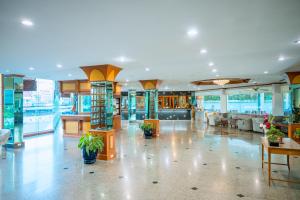 a large building with a lobby with plants in it at Viang Tak Riverside Hotel in Tak +65 photos