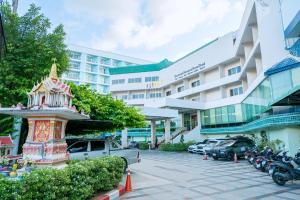 a hotel with cars parked in front of a building at Viang Tak Riverside Hotel in Tak