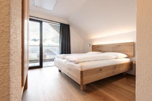 a bedroom with a bed and a large window at Senner Nature Stay in Riscone