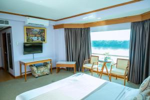 a hotel room with a bed and a large window at Viang Tak Riverside Hotel in Tak