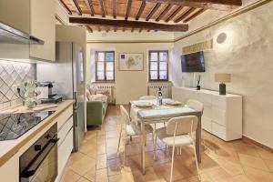 a kitchen and dining room with a table and chairs at Vicolo Nobile in Montepulciano