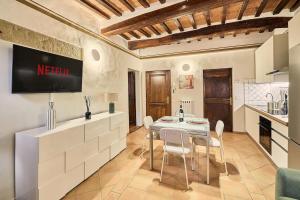 a kitchen and dining room with a table and chairs at Vicolo Nobile in Montepulciano