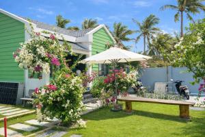 a garden with a bench and flowers at An Phú Villa in Cu Lao Thu +84 photos
