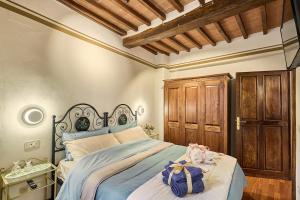 a bedroom with a bed with a blue comforter at Vicolo Nobile in Montepulciano