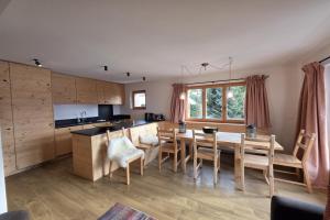 a kitchen and dining room with a table and chairs at Roxes 6, duplex cosy et lumineux à proximité de Médran in Verbier