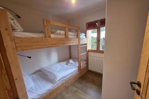 a room with two bunk beds and a window at Roxes 6, duplex cosy et lumineux à proximité de Médran in Verbier