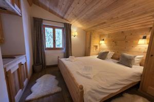a bedroom with a large bed in a wooden room at Roxes 6, duplex cosy et lumineux à proximité de Médran in Verbier