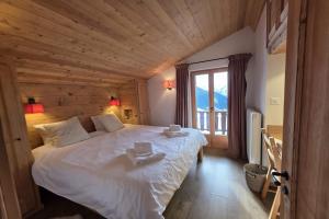 a bedroom with a large bed with a large window at Roxes 6, duplex cosy et lumineux à proximité de Médran in Verbier +3 photos