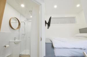 a small bathroom with a bed and a mirror at Viewpoint Pods in Dunollie