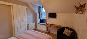 a bedroom with a bed and a window and a chair at Craigbuie Guesthouse in Killin
