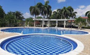 a large swimming pool with blue tiles on the ground at San ANTERO Cabaña Positano in San Antero