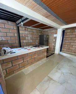 a kitchen with a counter and a brick wall at San ANTERO Cabaña Positano in San Antero