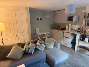 a living room with a couch and a kitchen at Cosy Flat, close to Bath Rugby and City Centre in Bath