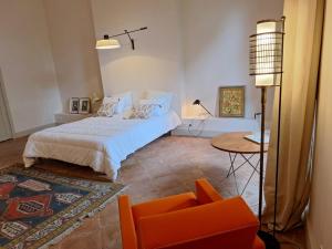 a bedroom with a bed and a chair and a table at Château de Savignac-Mona in Savignac-Mona