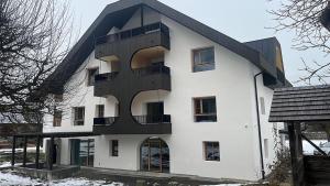 a large white building with a black roof at Senner Nature Stay in Riscone