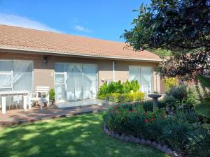 a house with a yard with flowers and plants at Ceelee's Place in Bloemfontein