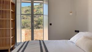 a bedroom with a bed and a large window at Eleonas Limeni in Limeni +39 photos