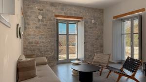 a living room with a table and chairs and a stone wall at Eleonas Limeni in Limeni