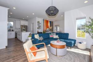 a living room with a blue couch and a kitchen at Nova's Nook in Auburn in Auburn
