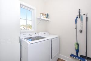 a white laundry room with a washer and a window at Nova's Nook in Auburn in Auburn +31 photos