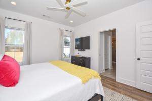 a white bedroom with a bed and a ceiling fan at Nova's Nook in Auburn in Auburn