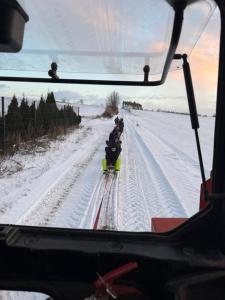 a group of people skiing down a snow covered road at Agroturystyka Wiejska Przystań Bory Tucholskie in Słupy +1 photo