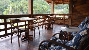 a restaurant with tables and chairs and a large window at Casa de campo rústica 21km vila germânica Bnu in Blumenau