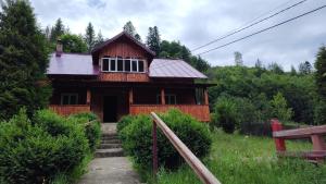 a wooden house with stairs leading up to it at Cabana Iraclie in Voronet