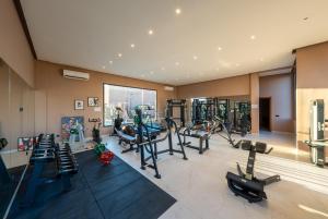 a gym with several treadmills and machines in a room at Villa Atlas - Luxe - 4 Suites Modernes - Fitness - Piscine Chauffée - Terrain de Padel - Vue Montagne in Marrakesh