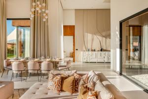 a living room with a couch and a table at Villa Atlas - Luxe - 4 Suites Modernes - Fitness - Piscine Chauffée - Terrain de Padel - Vue Montagne in Marrakesh