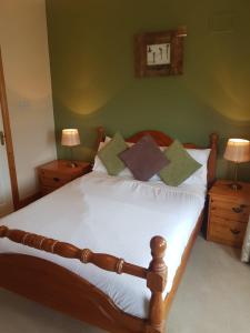 a bedroom with a bed with white sheets and pillows at Willow Lodge in Westport