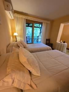 a bedroom with two beds and a window at Hotel Loma Bola in La Paz