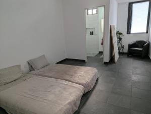 a large bed in a room with a chair at EstudioSuite Martinica Wifi Poliforum in Sofía