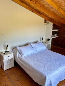 a bedroom with a bed and a wooden ceiling at Lirios del Cerro in Sierra de la Ventana