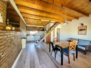a dining room and living room with a wooden ceiling at Lirios del Cerro in Sierra de la Ventana