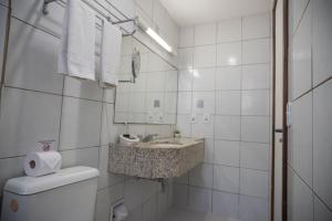 a white bathroom with a sink and a toilet at Abbeville Hotel Torre I - Torre II in São Luís +65 photos