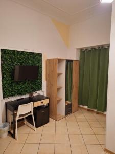 a living room with a tv and a desk at Fontanarossa Airport Home in Catania