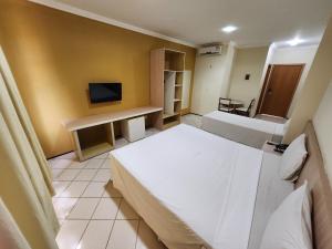 a hotel room with a large bed and a bathroom at Litorânea Praia Hotel in São Luís
