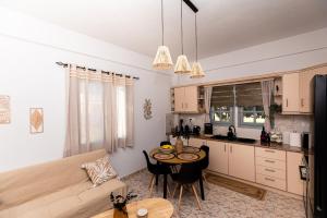 a kitchen and living room with a table and a couch at DM Seaside House in Perissa