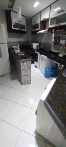 a large kitchen with white tile floors and a counter at Casa inigualavel in Caucaia
